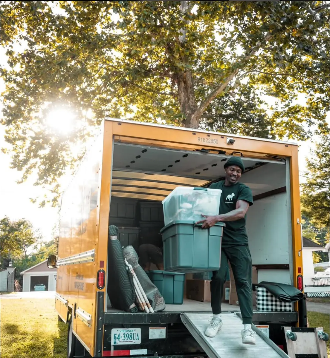Mover loading a plastic bin into a moving truck