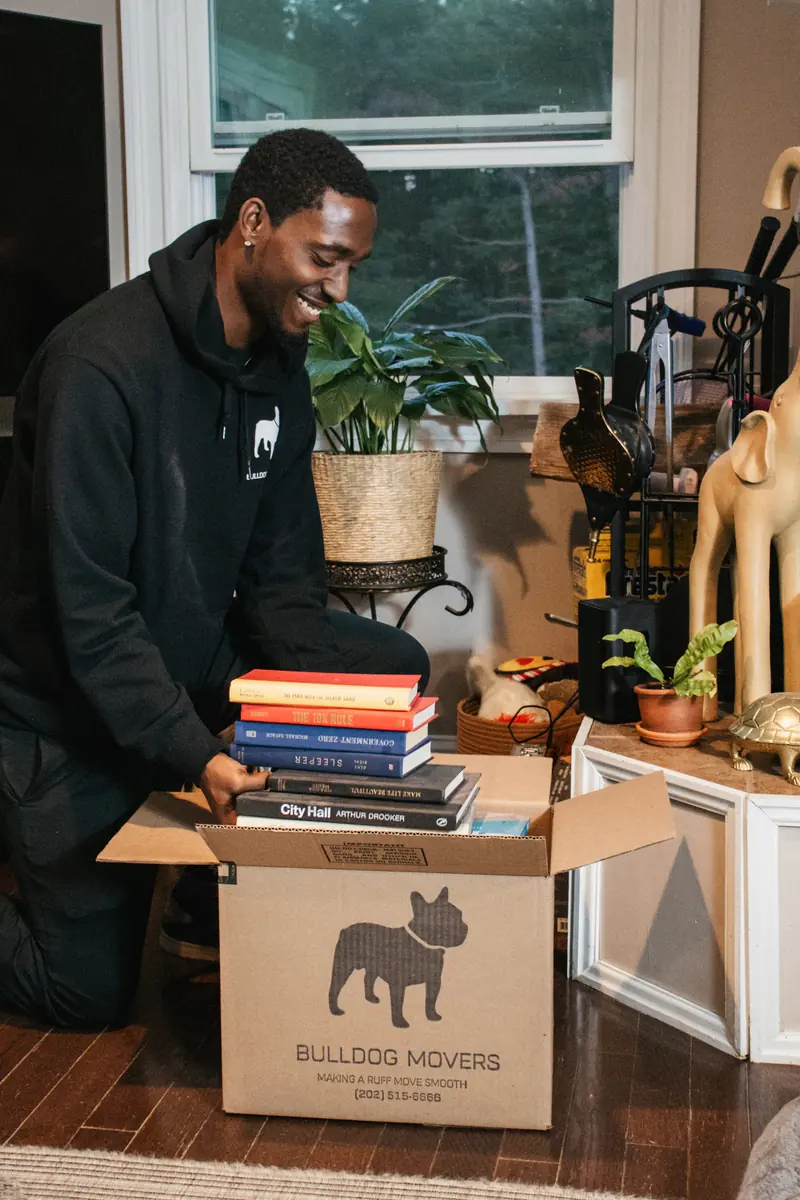 Mover packing books into a branded moving box