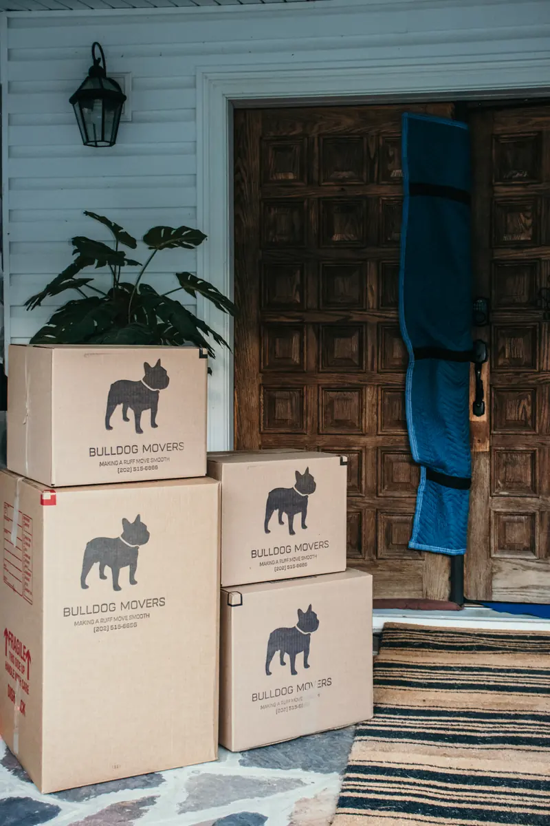 Stack of branded moving boxes outside a front door
