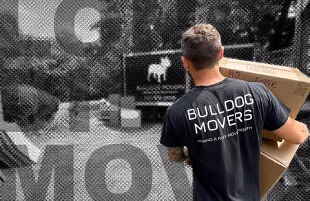 Bulldog Movers team member carrying a moving box